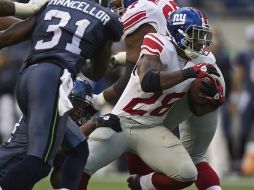 El jugador de los Gigantes, Danny Ware, trata de escapar ante los defensivos de Seattle. EFE  /