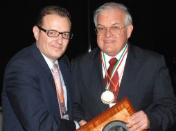 El doctor Roberto Espinosa (der) recibe la distinción de manos de su colega Víctor Sáenz. ESPECIAL  /