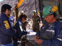 Policías toman la declaración de uno de los mineros que atestiguó el accidente en la mina Los Reyes. AFP  /