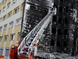 Bomberos buscaron supervivientes tras el incendio en un edificio de residentes inmigrantes. EFE  /