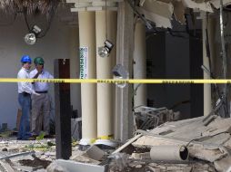 Dos trabajadores inspeccionan la zona del hotel que explotó el domingo pasado, en Playa del Carmen, Quintana Roo. AP  /