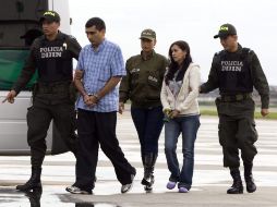 Miembros de la Policía Nacional de Colombia custodian hoy a dos de los tres supuestos guerrilleros extraditados desde Venezuela. EFE  /