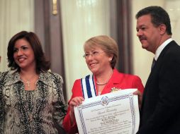 Michelle Bachelet (c), es condecorada por Leonel Fernández (d), y su esposa, Margarita Cedeño (i). EFE  /