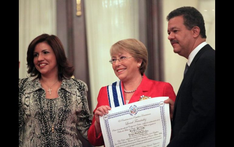 Michelle Bachelet (c), es condecorada por Leonel Fernández (d), y su esposa, Margarita Cedeño (i). EFE  /