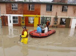 Un brigadista apoya a una familia, cuya casa situada en un barrio de Bogotá está inundada. REUTERS  /