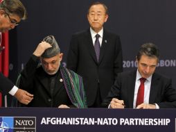 Hamid Karzai, Anders Fogh Rasmussen  y   Ban Ki-moon  firmando el acuerdo  ante el secretario general. REUTERS  /
