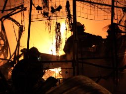 Aspecto del combate de bomberos tapatíos contra el fuego que envolvió el tianguis navideño del Jardín de la Reforma. A. HINOJOSA  /