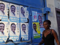 Una mujer camina por las calles de Puerto Príncipe donde pueden verse carteles de los candidatos a la presidencia. REUTERS  /