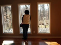 Una mujer observa a través de una ventana de una casa que se encuentra en un juicio hipotecario en Oxford, Connecticut. AFP  /