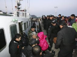 Residentes de Yeonpyeong abordan embarcaciones para alejarse de la isla afectada por las agresiones de Corea del Norte. AP  /