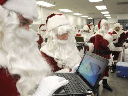 Empleados de una aerolinea se disfrazan de Santa Claus en unión con Microsoft para agazajar a sus clientes. AP  /