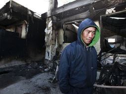 Un residente pasa hoy por un par de casas destruidas en la isla surcoreana de Yeonpyeong. EFE  /