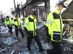Policías surcoreanos revisan las zonas devastadas por el ataque del martes en la isla de Yeonpyeong. AP  /