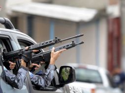 Miembros de la policía federal vigilan desde un vehículo, durante el operativo policial en la favela de la Grota. EFE  /