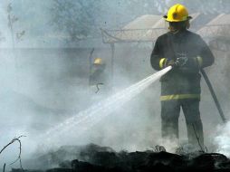 Personal de bomberos, acudieron para tratar de sofocar el incendio, pero este ya se había propagado sobre las viviendas. ARCHIVO  /