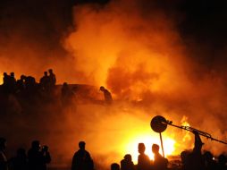 Bomberos paquistaníes extinguen el fuego causado por el avión de carga de fabricación rusa. AFP  /
