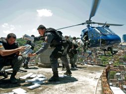 Policías cargan a un helicóptero los paquetes de mariguana incautada en el Complexo do Alemao, en Río de Janeiro. EFE  /