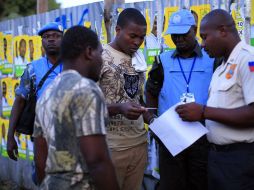 Autoridades verifican las identificaciones de cada uno de los votantes haitianos que llegan a sufragar, en Haití. REUTERS  /