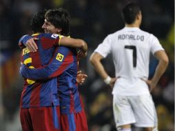 Los jugadores del Barcelona festejan la victoria mientras Cristiano Ronaldo se lamenta por no poder hacer anotaciones. AP  /
