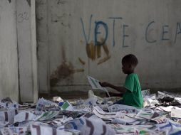 Un niño juega con papeletas electorales en un colegio votante de un campo de desplazados. EFE  /
