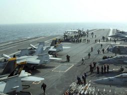 Soldados estadounidenses preparan varios aviones en la cubierta del portaaviones George Washington. AFP  /