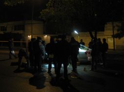 Autoridades y peritos alrededor del automóvil en que viajaban los agentes federales ejecutados. O. RUVALCABA  /