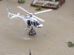 Un helicóptero baja provisiones de agua y comida para las víctimas de inundaciones en Barlovento, Caracas. REUTERS  /