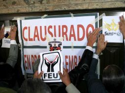 Miembros de la UdeG clausuraron simbólicamente Casa Jalisco, al colocar calcomanías alusivas en sus puertas. E. PACHECO  /