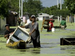 Habitantes de Campo de la Cruz, situado al norte de Bogotá, huyen de la inundación con las pocas pertenencias que les quedan. EFE  /