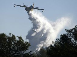 Un avión lanza agua sobre las llamas en el monte Carmelo para contrarrestar el incendio. REUTERS  /