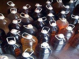 Durante el cateo, las autoridades encontraron botellas y barricas llenas de producto falso que fueron decomisadas. ESPECIAL  /