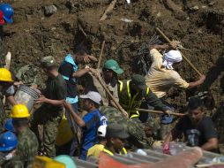 Rescatistas y vecinos de la localidad de Bello, remueven la tierra en busca de sobrevivientes. AFP  /