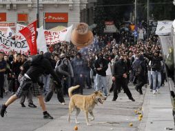 Estudiantes lanzan piedras y macetas a policías en un edificio del Gobierno en el Centro de Atenas. AP  /