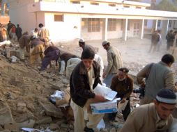 Hombres ayudan a limpiar los escombros en el sitio de un atentado suicida. REUTERS  /