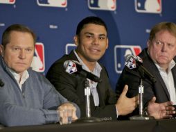 El dominicano Carlos Peña acompañado de su agente Scott Boras y del vicepresidente general del club Chicago Jim Hendry. AP  /