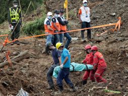 Socorristas trasladan un cuerpo sin vida tras un deslizamiento de tierra el domingo pasado en el municipio de Bello, (Colombia). EFE  /