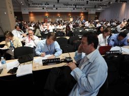Delegados de varios países analizan documentos en el marco de las negociaciones de la conferencia de cambio climático. AFP  /
