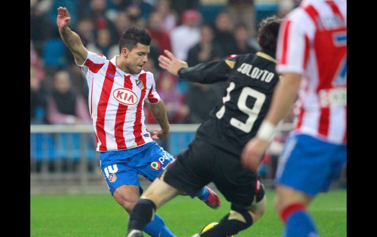 El 'Kun' hace un quiebre para quitarse la marca de Diego Colotto, en el partido de hoy. EFE  /