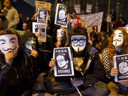 Partidarios del fundador de WikiLeaks muestran carteles con su foto durante una protesta frente a la Embajada británica en Madrid. AP  /