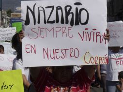 Un hombre sostiene un cartel que dice ‘‘Nazario siempre vivirá en nuestros corazones’’. AP  /