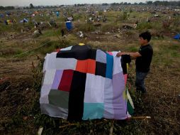 Un hombre extiende sus refugios en el barrio de Villa Soldati, en Buenos Aires. AP  /
