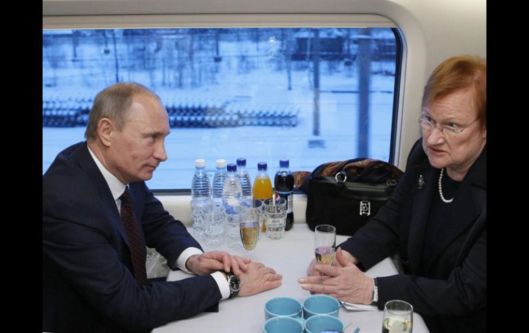 El premier ruso Vladimir Putin y la presidenta de Finlandia, Tarja Halonen, conversan en el flamante tren. REUTERS  /