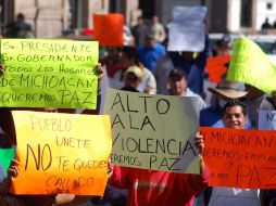 Personas sostienen cartulinas con consignas contra el Gobierno y policías federales en Morelia. REUTERS  /