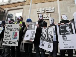 Simpatizantes de Julian Assange portan carteles en los que piden su libertad, afuera de la embajada sueca en Londres. AP  /