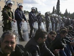 Un grupo de policías custodian el parlamento ante las diversas protestas que se han disparado en por los próximos recortes. EFE  /
