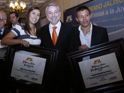 La arquera Linda Ochoa y el clavadista Germán Sánchez posan con sus reconocimientos junto al gobernador de Jalisco. M. FREYRÍA  /