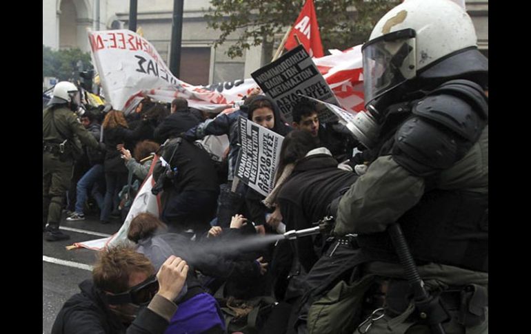 Varios policías antimotines se enfrentan a un grupo de manifestantes frente a las puertas del Parlamento en Atenas. EFE  /