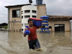 Un habitante del sector La Dolores, en zona rural de Palmira, sale con algunas de sus propiedades. EFE  /