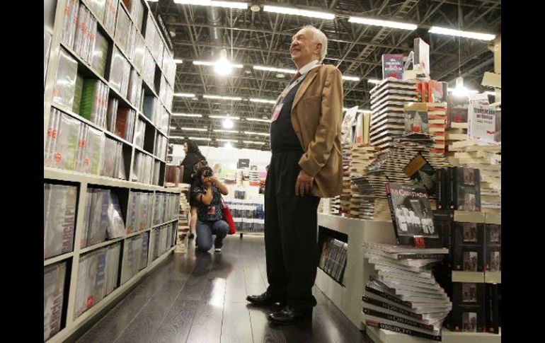 El escritor Sergio Pitol sonríe al ver que una joven le toma una fotografía en el stand del Fondo de Cultura Económica. A. CAMACHO  /