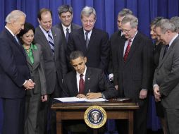 El presidente de EU, Barack Obama (centro), promulgó la ley de recortes de impuestos que acordó con los líderes republicanos. AP  /